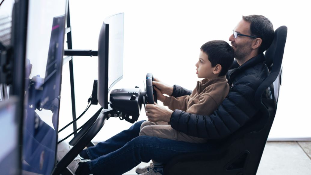 Padre e hijo disfrutan de la experiencia de conducir el Porsche 911 GT3 RS en el simulador durante el Family Day. Lima, Per&uacute;. Porsche AG.